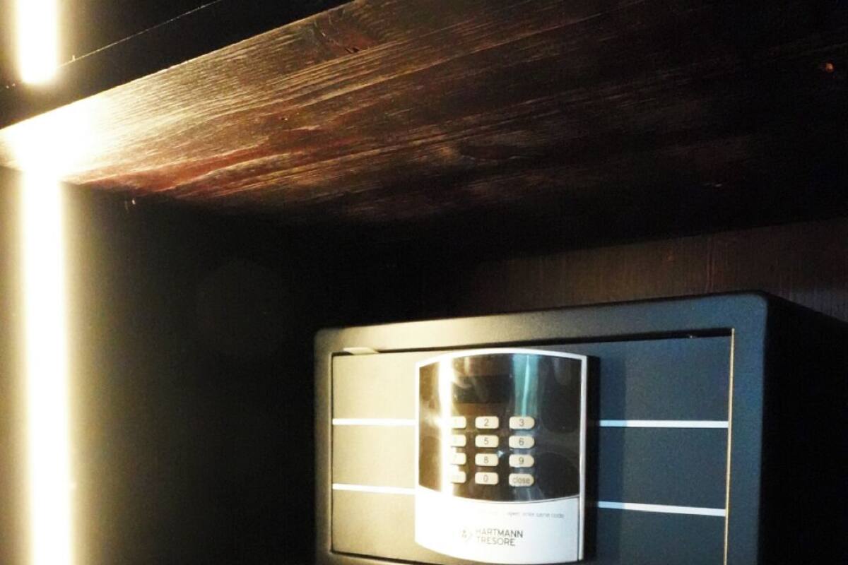 A digital keypad device on a wooden shelf.