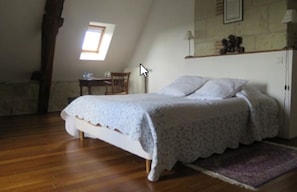 A bedroom with a bed, a desk, and a window. - Manoir de L'abbaye (Seuilly)