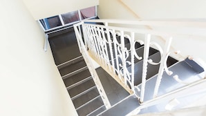 A staircase with white railings and a black floor. - Jacksonfields Apartments (Accra)