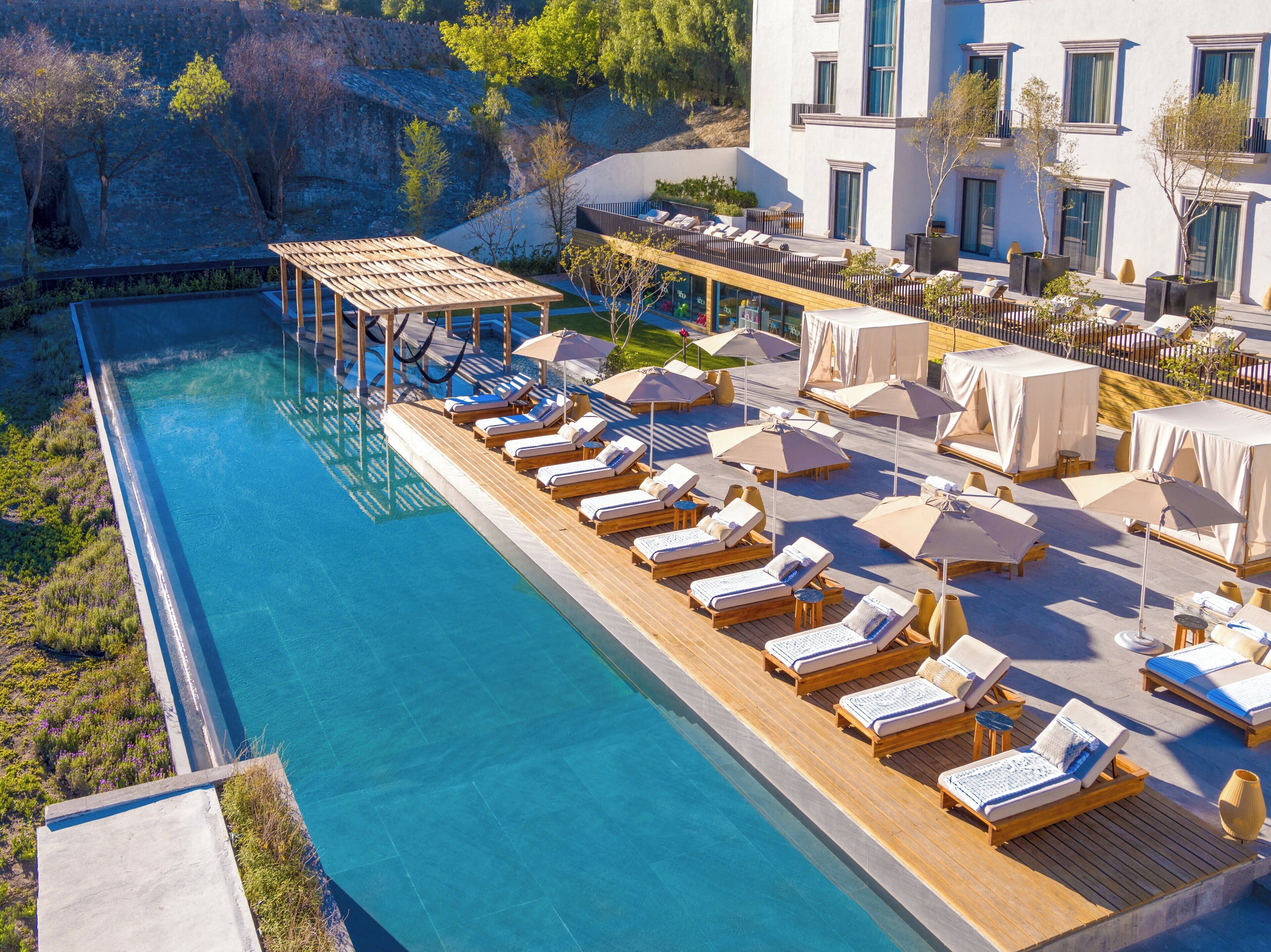 Una piscina al aire libre, camas de piscina gratis, sombrillas