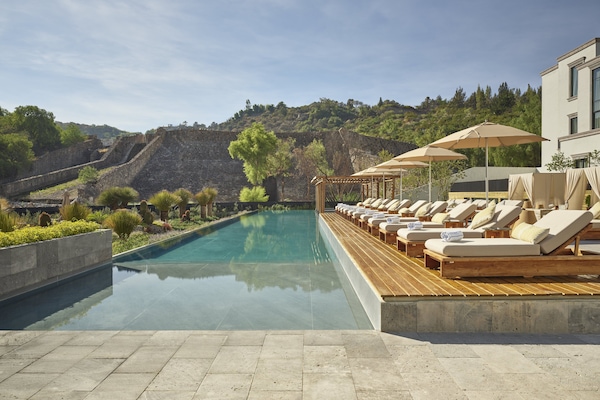 Una piscina al aire libre, camas de piscina gratis, sombrillas