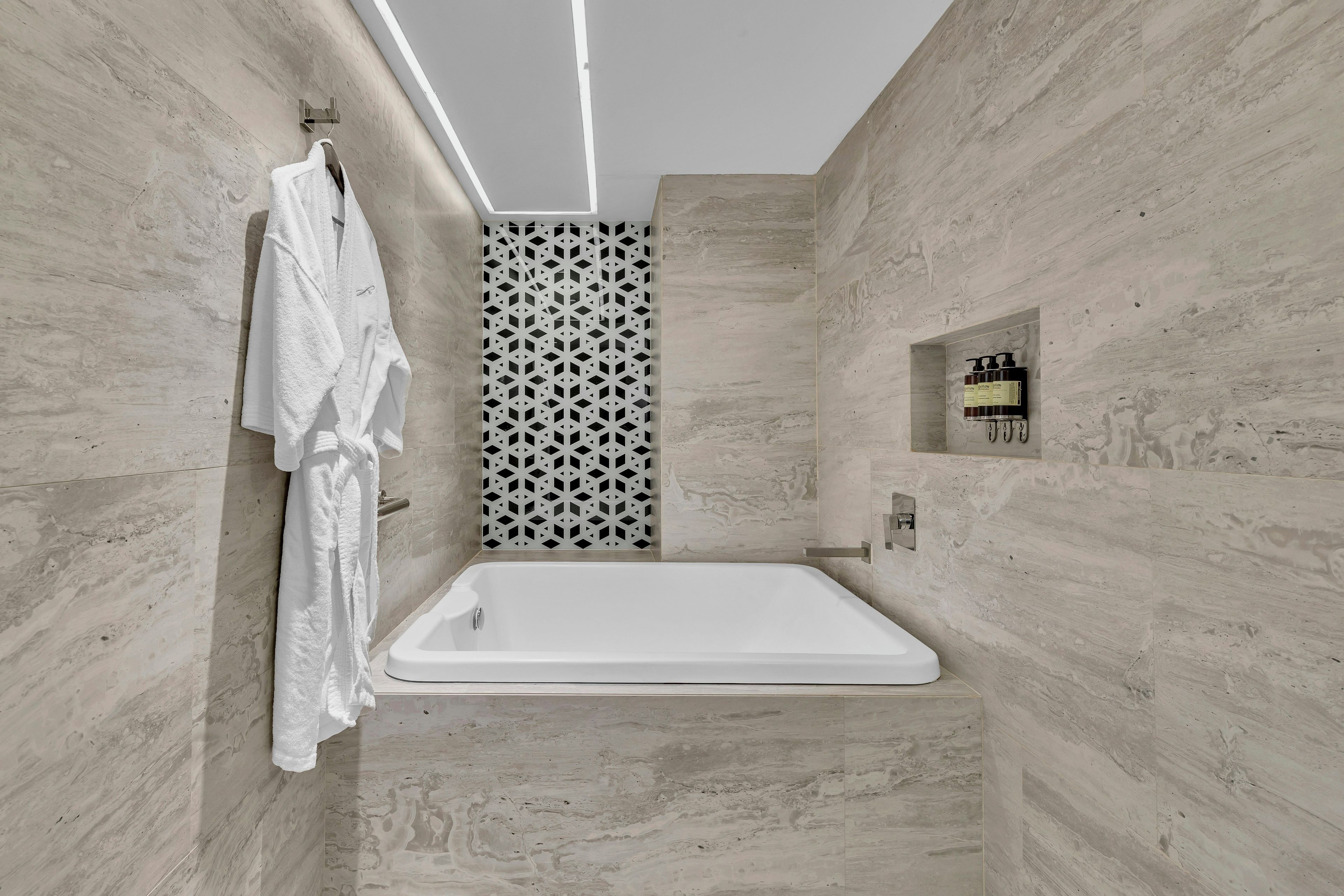 A modern bathroom with a freestanding bathtub, a towel rack, and a shower control panel.