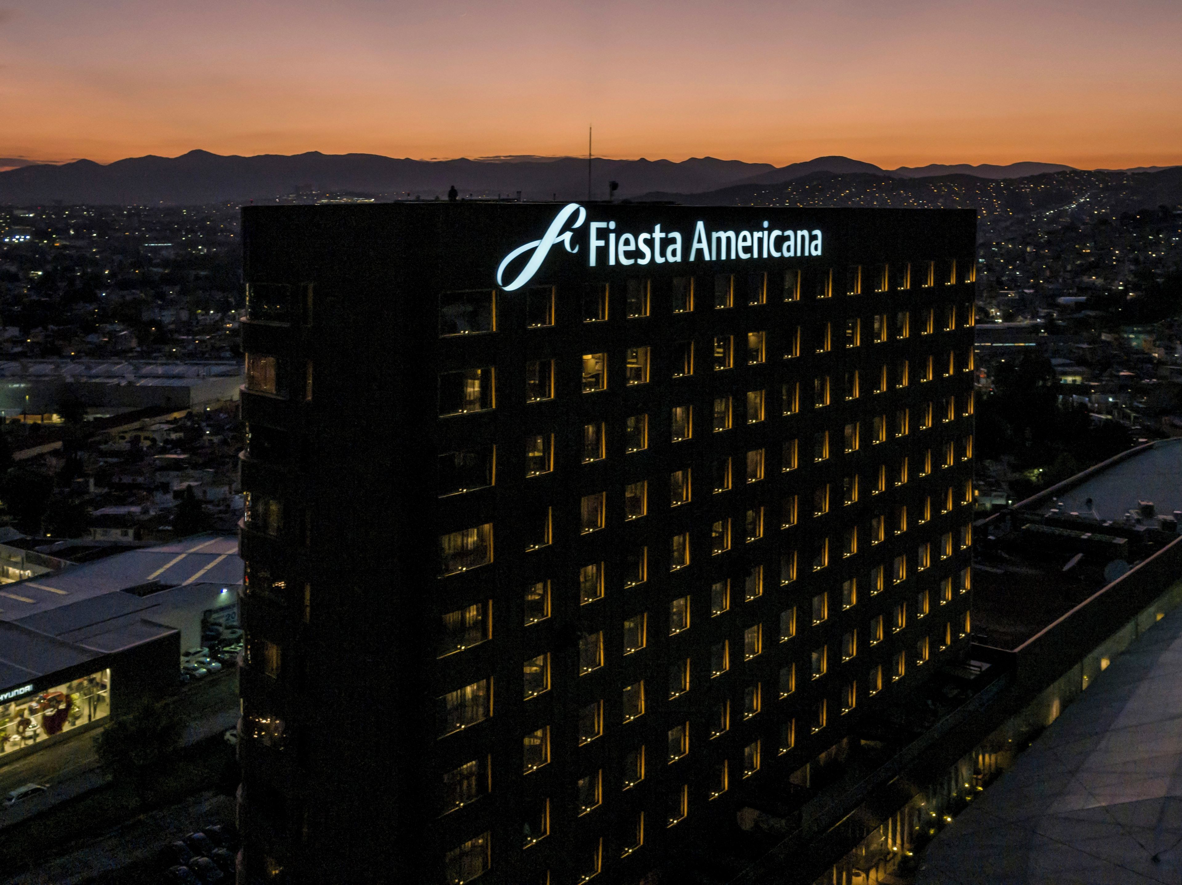 Un edificio alto con un letrero llamativo que dice 'Fiesta Americana'.