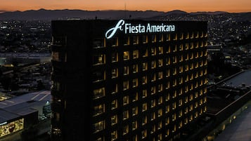 Un edificio alto con un letrero llamativo que dice 'Fiesta Americana'.