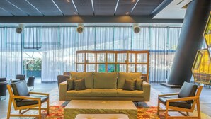 A spacious lobby with a large sofa, two armchairs, and a matching ottoman.