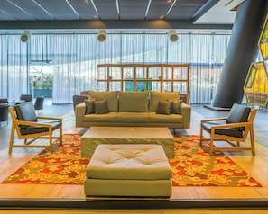 A modern lobby with a sofa set, chairs, and a patterned rug. - Fiesta Americana México Satélite (Tlalnepantla de Baz)