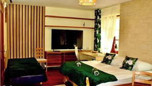 Habitación de hotel con cama, escritorio, silla y televisor.