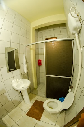 A bathroom with a toilet, sink, and shower. - Pousada Azul do Mar (Penha)