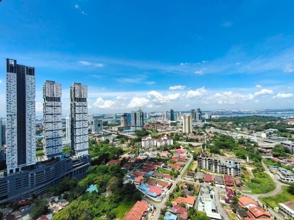 A cityscape with modern high-rise buildings, a mix of residential and commercial structures, and a clear blue sky.
