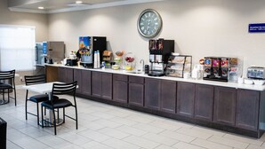 Un comptoir pour prendre le petit-déjeuner, avec une horloge, des machines à café et un espace pour s’asseoir.