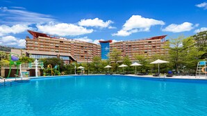 A hotel with a large swimming pool, multiple balconies, and a modern building design. - Four Points by Sheraton Guangdong, Heshan (Jiangmen)