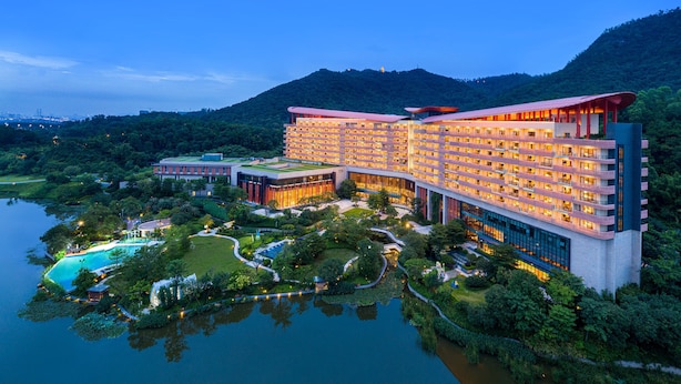 A large hotel with multiple floors, a swimming pool, and lush greenery surrounding the property. - Four Points by Sheraton Guangdong, Heshan (Jiangmen)