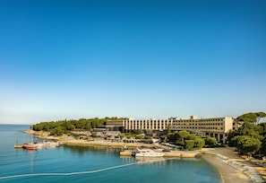 A coastal hotel with a marina, a large building with multiple floors, and a beach area. - Maistra Select Island Hotel Istra (Rovinj)