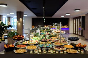 Un bufé con diversos postres y frutas.