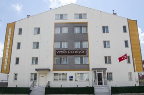 A multi-story building with a sign reading "Venüs Pansiyon" and a Turkish flag. - Venüs Pansiyon (Çanakkale)