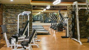 Une salle de sport équipée de tapis de course, de vélos elliptiques et de matériel de musculation.