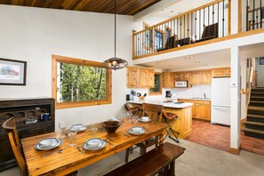 Enjoy meals in this dining area with a table for four, a large bowl, and wine glasses.
