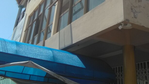 Een gebouw met meerdere verdiepingen, grote ramen en een balkon.