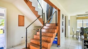 A wooden staircase with metal railings leading to an upper floor.