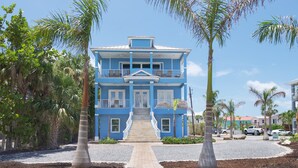 A two-story building with a blue exterior, a central entrance with steps, and a balcony on the upper floor. - Bay Views- Private Pool- Great Location- 5BRBlue Horizon (Fort Myers Beach)