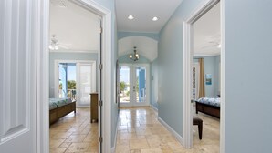 A hallway with a bed, a bench, and a door leading to a balcony. - Bay Views- Private Pool- Great Location- 5BRBlue Horizon (Fort Myers Beach)