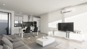 Una sala de estar moderna con un amplio sofá modular, un televisor de pantalla plana y una mesa de centro minimalista.