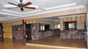 A spacious lobby with a high ceiling, a ceiling fan, and a patterned wall. - Villa D' Coco (Accra)