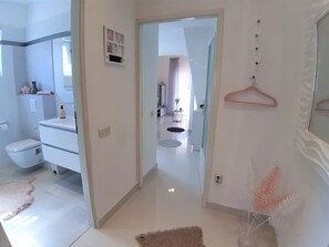 Een bad/douchecombinatie, een haardroger, handdoeken, zeep