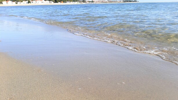 A beach with clear water, a sandy shore, and buildings in the background. - Apartment Kristina 400 m from the sandy beach + air condition + WiFi +dishwasher (Medulin)