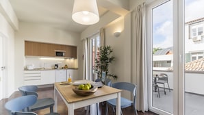 Una cucina moderna con zona pranzo, ampie finestre e vista esterna.