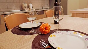 A dining table set with plates, wine glasses, and a rose centerpiece. - Cozy Apartment • Pool • close to Trogir & Airport (Trogir)