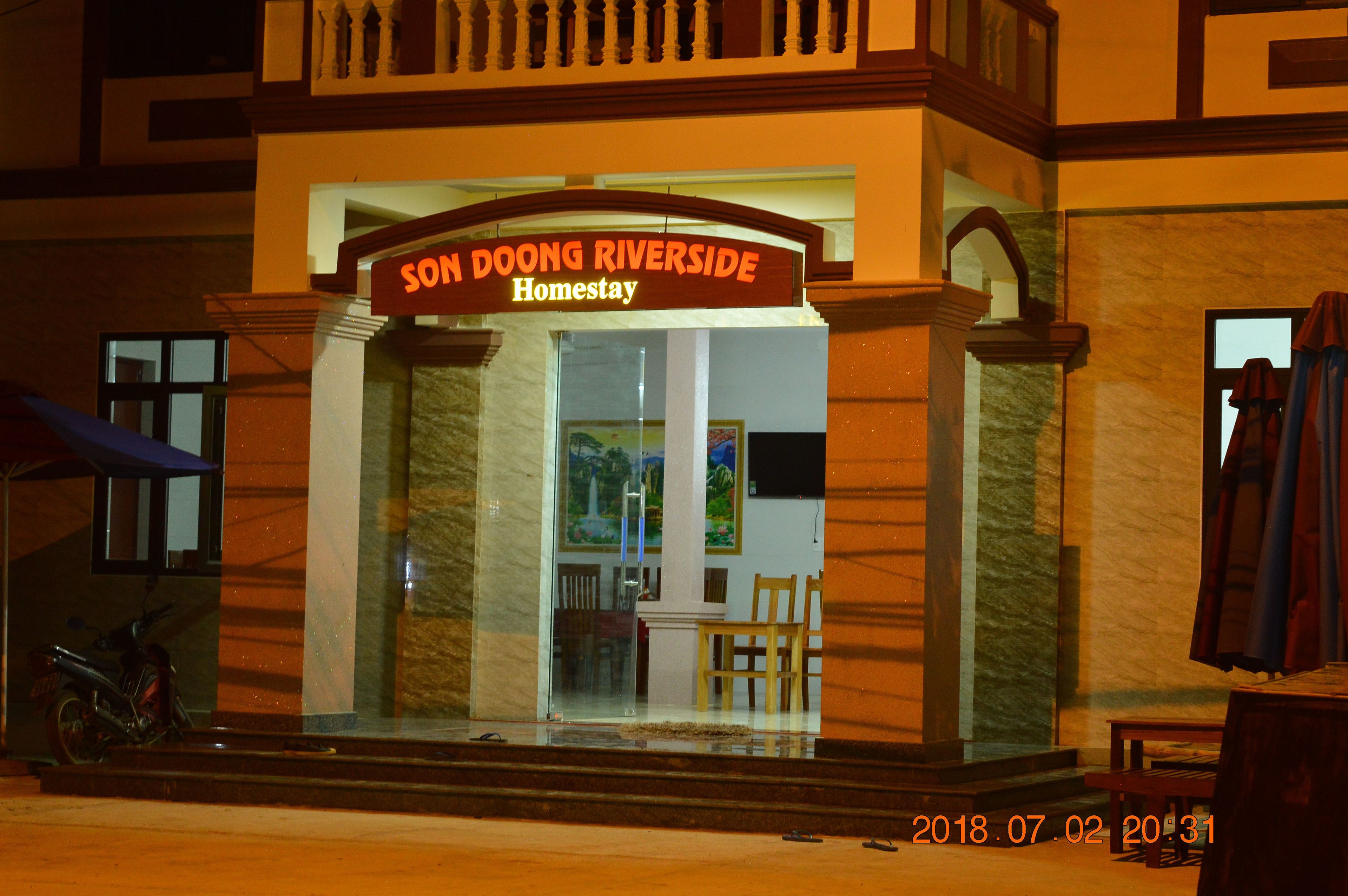 A hotel entrance with a sign reading "SON DOONG RIVERSIDE Homestay."