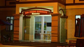Entrada de un hotel con un letrero que dice "SON DOONG RIVERSIDE Homestay".