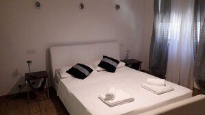 A neatly made bed with white linens, two black and silver pillows, and a folded white towel on the bed. - Nightlife but quiet area, modern large home, bayview, garden, bbq, parking (St. George's Bay)