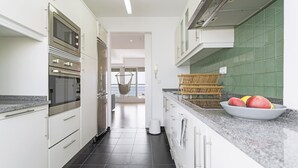 A modern kitchen with white cabinets, stainless steel appliances, and a granite countertop.