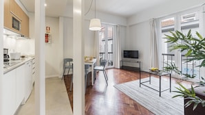 A modern apartment with a kitchen, dining area, and living room.