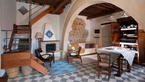 A rustic interior with a checkered floor, wooden furniture, a staircase, and a stone wall. - Charming house with shared pool - Titi (Buseto Palizzolo)
