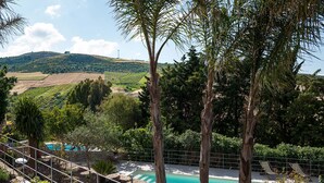 A pool area with lounge chairs, surrounded by trees and a view of vineyards. - Charming house with shared pool - Titi (Buseto Palizzolo)