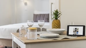 A neatly arranged breakfast table with a pineapple, glasses, and a tablet displaying a menu. - Downtown Funchal Apartments 2C 25 Fontes. (Funchal)