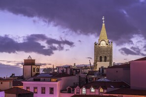 Un edificio histórico con una torre de reloj, rodeado de edificaciones residenciales.