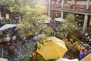 Un mercado cubierto con varios puestos y gente comprando.