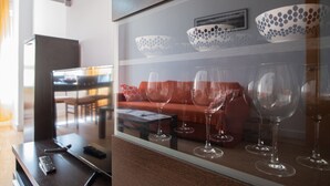 Habitación de hotel con separador de vidrio que muestra copas de vino y cuencos.