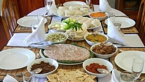 A dining table set with various dishes, including rice, flatbreads, and bowls of food, in a restaurant setting. - Tea Leaf Retreat Peradeniya (Doluwa)