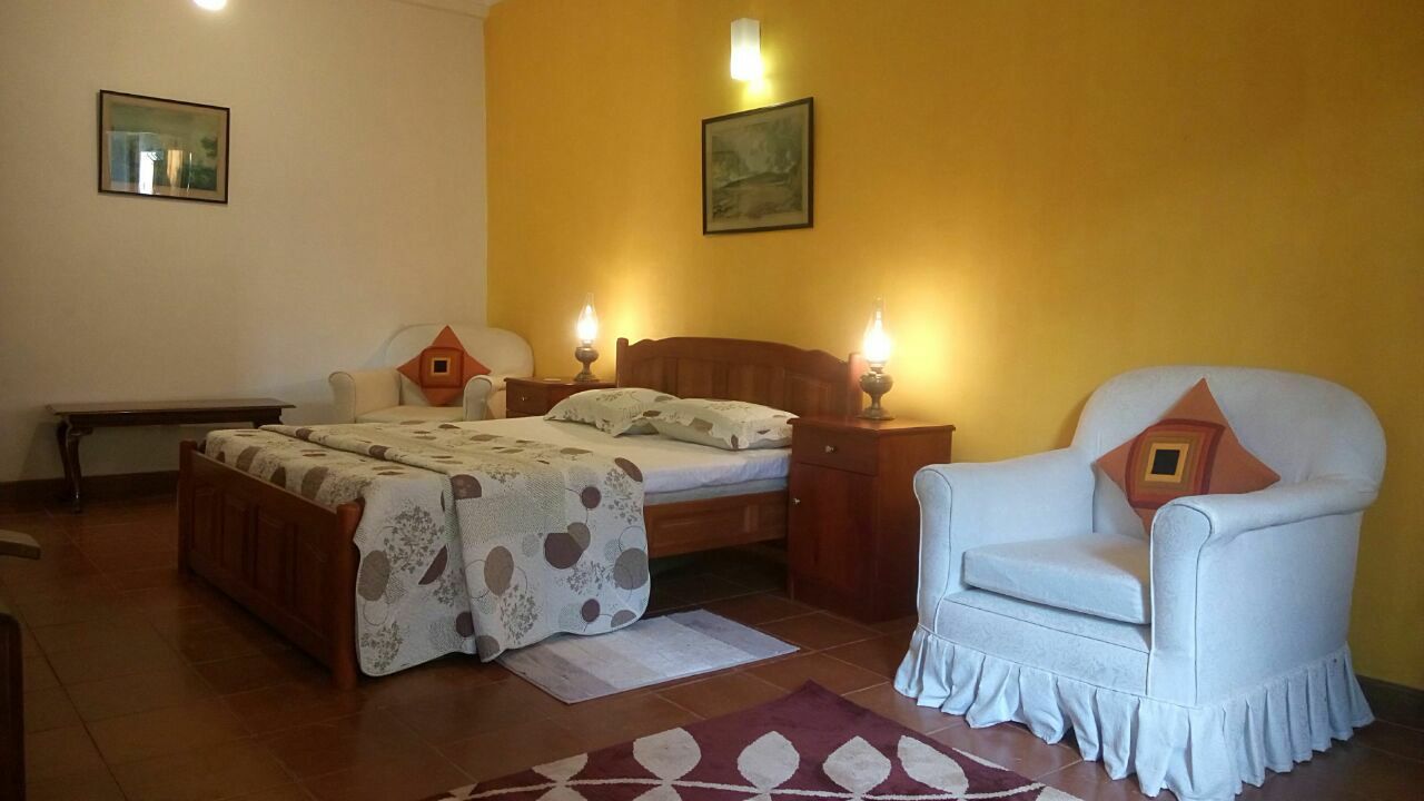 A bedroom with a bed, bedside tables, a chair, and a rug.