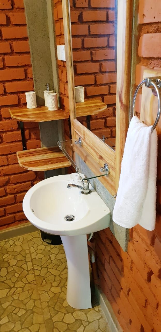 A bathroom with a white sink, a mirror, and a towel rack.