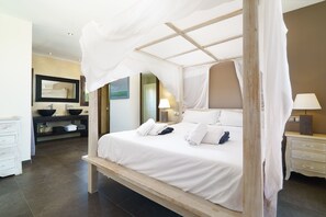 Cozy retreat with a canopy bed, bedside table, and large mirror.