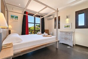 A bedroom with a bed, a dresser, and a window with a view of greenery.