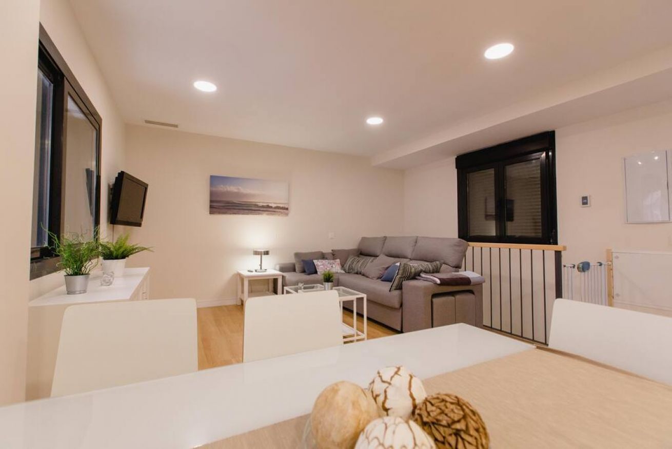 Ett modernt vardagsrum med en soffa, ett soffbord och ett matbord.
