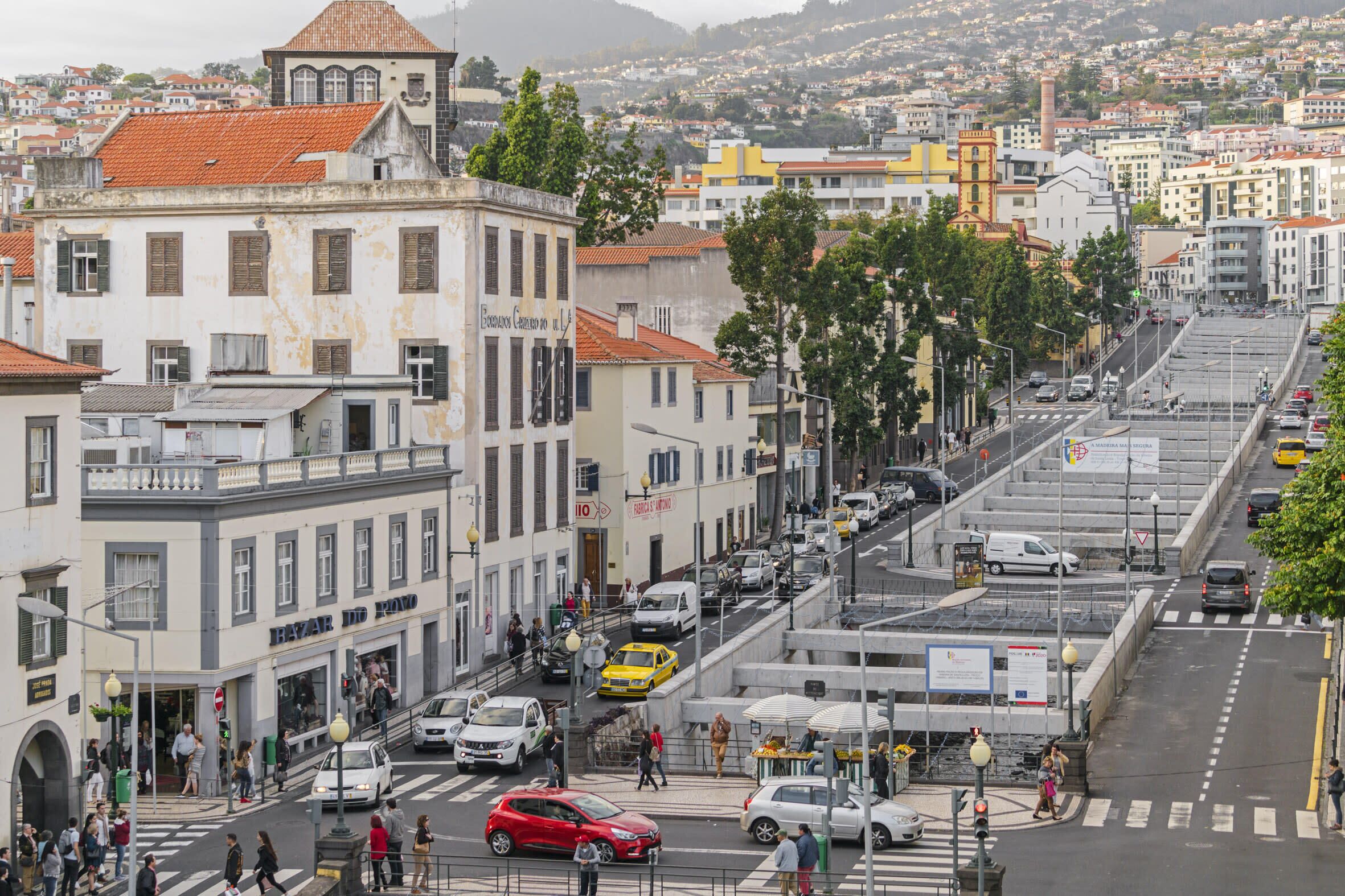 A busy urban street with buildings, cars, and pedestrians.