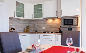 Enjoy a meal in the compact kitchen with a gas stove, microwave, and wavy-patterned backsplash.